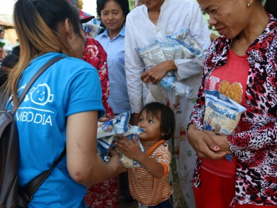 A girl from Kinship Cambodia distributing food packets