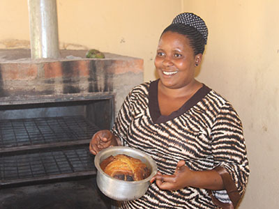 A women from Uganda baking a cake