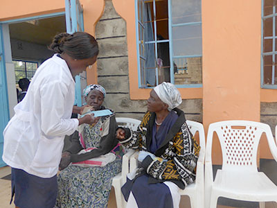 A doctor consults with two patients at the medical clinic in Kenya.
