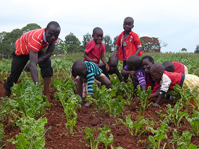 Henry Rajab teaches other Kinship Kids about farming.