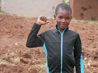 Young boy stands smiling