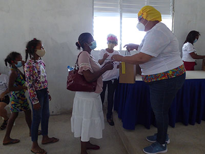 A Kinship Project member hands out hygiene supplies to community members.