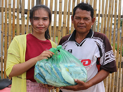 A Cambodian man receiving food from our Kinship Project