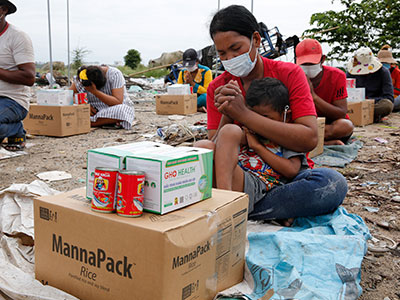 A woman prays over the food she received in Cambodia