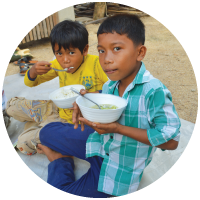 Children with bowls of food in Cambodia