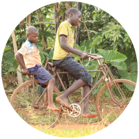 Children in Uganda riding a bike