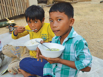 Children with bowls of food in Cambodia
