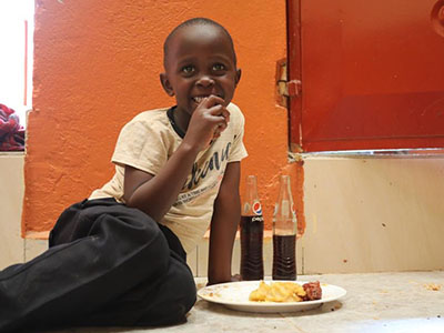 A child eating a Christmas meal at the Buloba Kinship Project