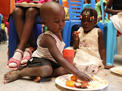 Children eating a Christmas meal at the Buloba Kinship Project