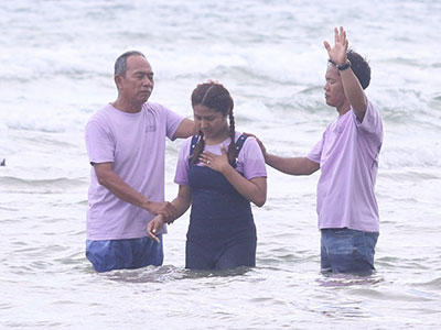 A young woman being baptized during the youth conference
