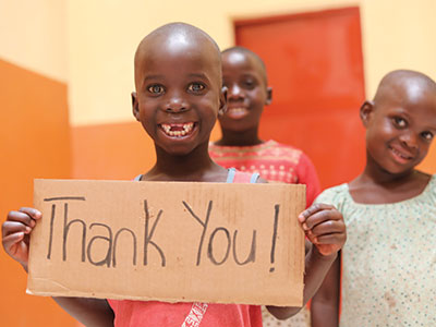 A child holding up a "Thank You" sign