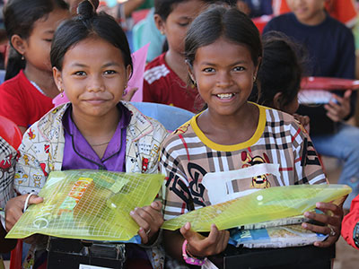 Children in Cambodia holding their new school supplies