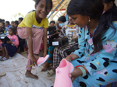 Children in Cambodia putting on their new sneakers