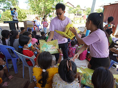 Children in Cambodia putting on their new sneakers