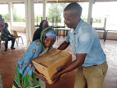 Pastor Richard giving a box of meals to an older woman