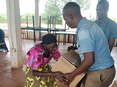 Pastor Richard giving a box of meals to an older woman