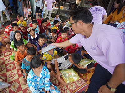 Pastor Jack handing out school supplies to children in Cambodia