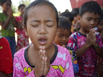A young girl in Cambodia praying