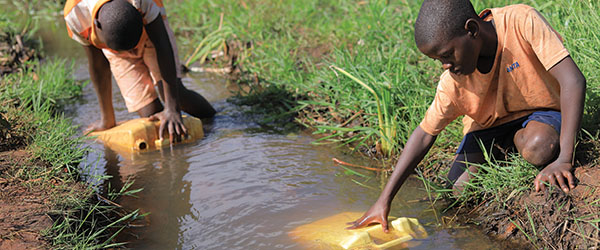 A child gathering dirty water from a river