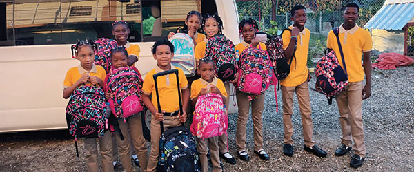 Children with their backpacks in the DR