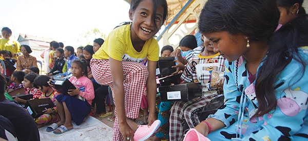 A smiling child putting on her new shoes