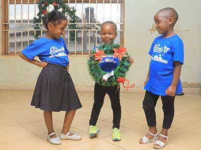 Children holding up a Christmas wreath