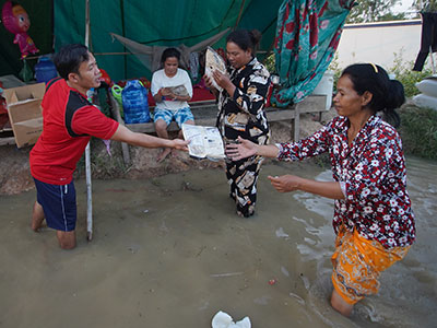 Pastor Jack handing out food to families during the Phnom Penh flooding