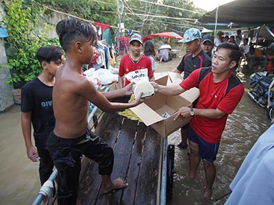 Pastor Jack handing out food to children during the Phnom Penh flooding