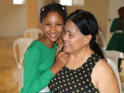 A Cayacoa Kinship Kid smiles with her caregiver