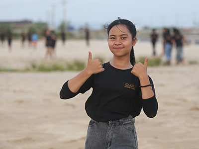 A young adult giving thumbs up