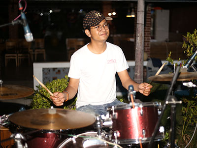 A young man playing the drums
