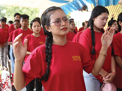 A girl worshipping during an annual youth camping trip in Cambodia