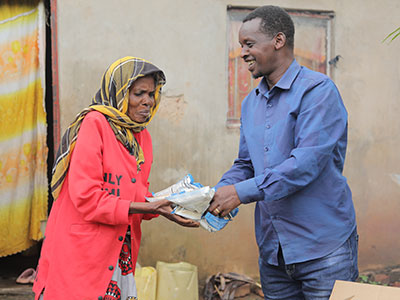 A grateful widow accepting food during outreach