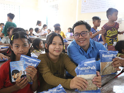 Pastor Jack smiling with MannaPack recipients during an outreach event