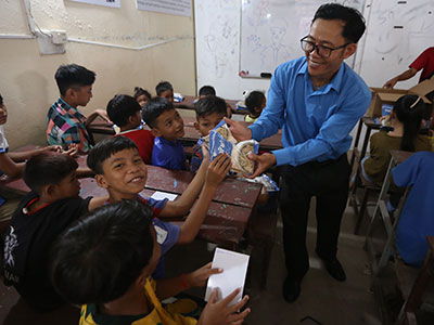 Pastor Jack handing MannaPack meals to a smiling recipient