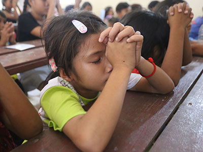 A child praying during an outreach event