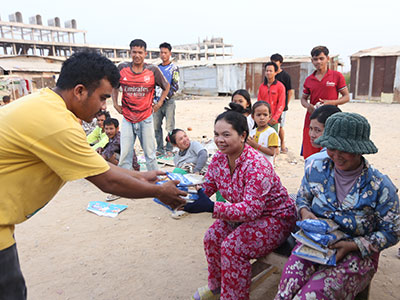 A team member handing out MannaPack meals during an outreach event.