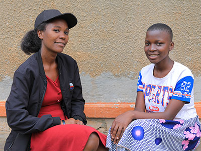 Two smiling young women sitting next to each other