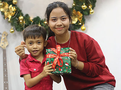 A young child in Cambodia receiving a Christmas present