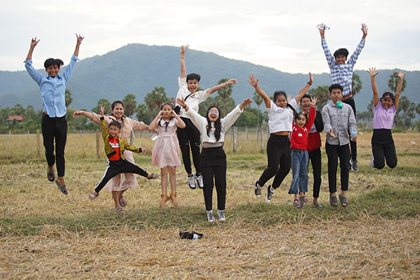 A row of children jumping up in celebration