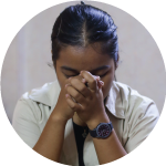 A young woman bowing her head in prayer