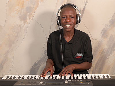 A smiling young man playing the piano