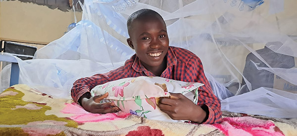 A smiling children hugging their pillow