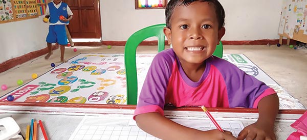 A child writing his answer during school