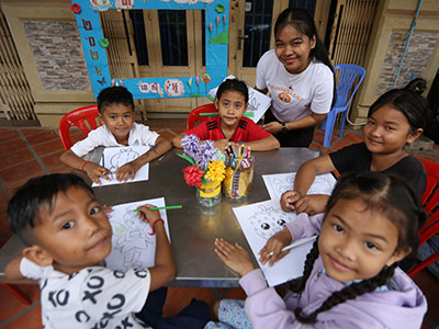 Children color during the Back to School Sunday School event in Cambodia.