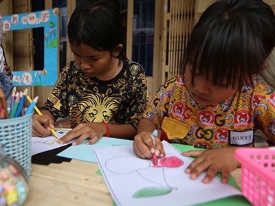 Children color during the Back to School Sunday School event in Cambodia.