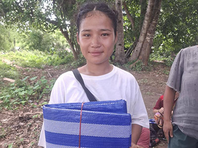 A woman holding her folded blue tarp