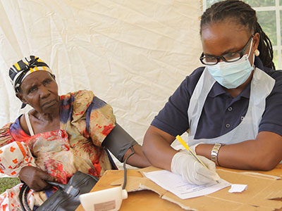 A woman gets her blood pressure checked during a medical outreach event in Uganda