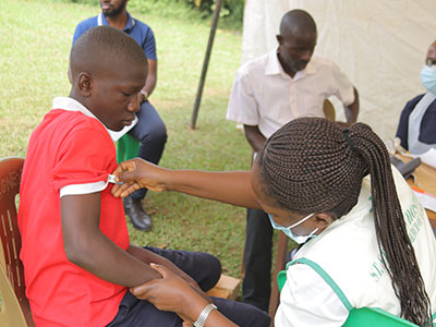 A boy gets his temperature checked during a medical outreach event in Uganda