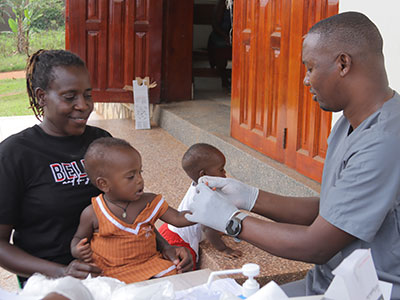 A mother holds her child as they receive medical care